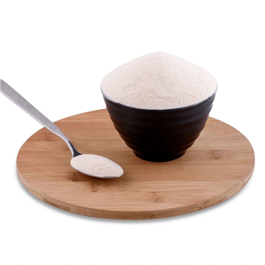 Agar agar powder in brown bowl and spoon on wood board isolated on white background, copy space.